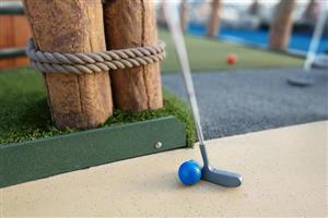 Mini golf course with a putter and bright blue ball.
