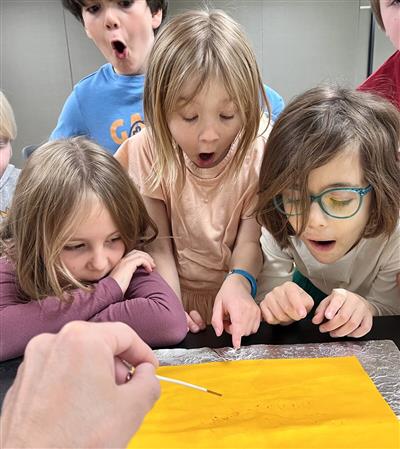 picture of kids in awe at chemical reaction